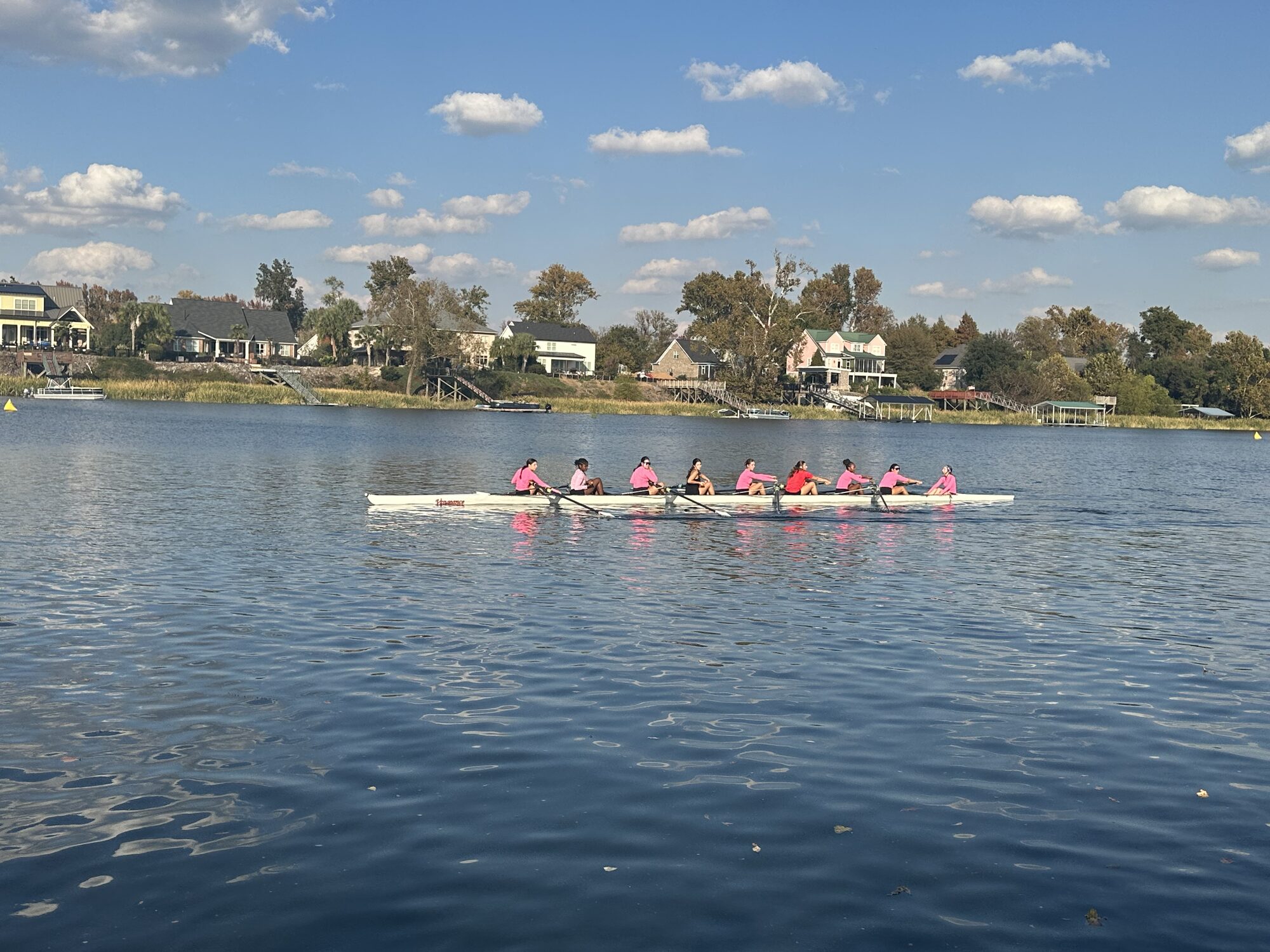 LBRA girls 8+ wearing pink jerseys racing past houses on the Augusta course